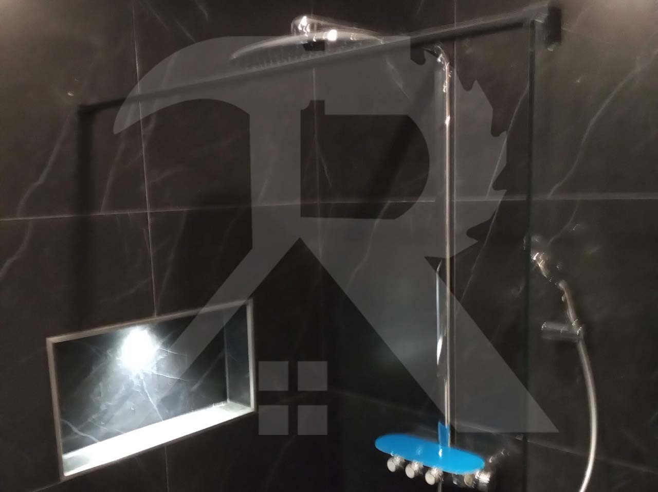 Douche met donkere marmerlook tegels en een verlichte nis