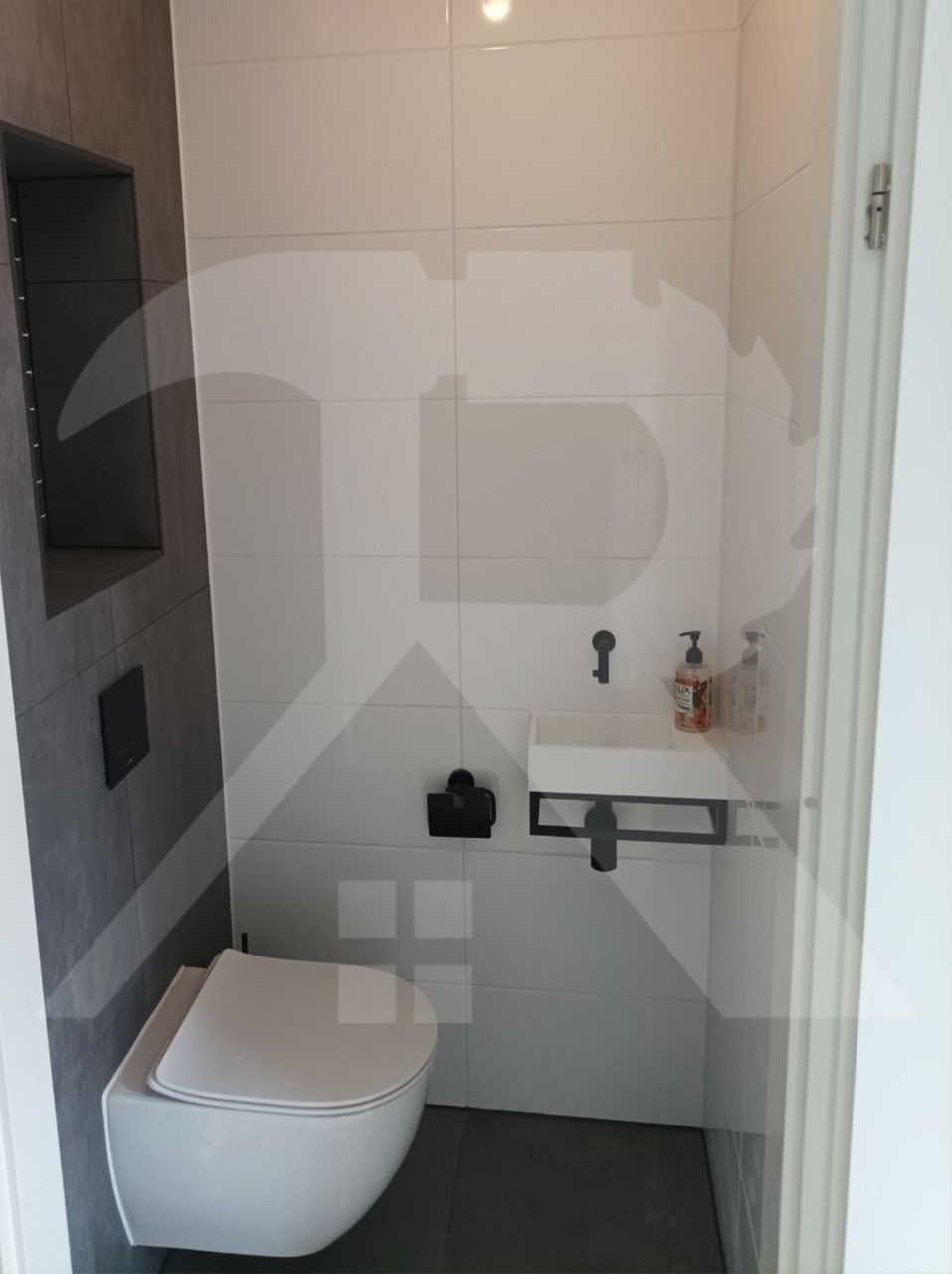 Toilet met zwart fonteintje op een beugel