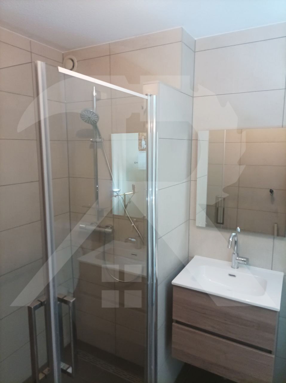 Dezelfde badkamer na de renovatie met glazen douchewand en zwevend badmeubel