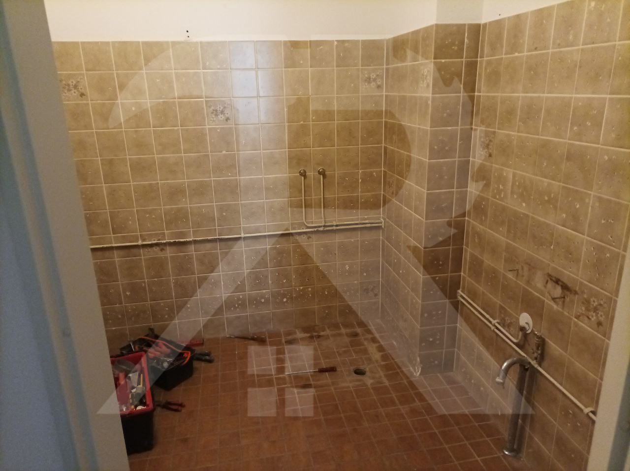 Badkamer met bruine tegels tijdens het slopen